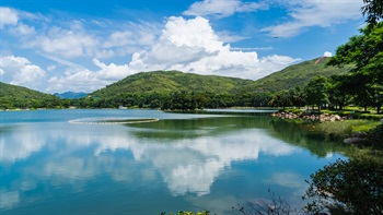 平静开阔的迪欣湖映照着蓝天和大屿山的起伏山峦，例如大山和大阴顶，景色怡人，宁静优美，远离闹市的烦嚣。